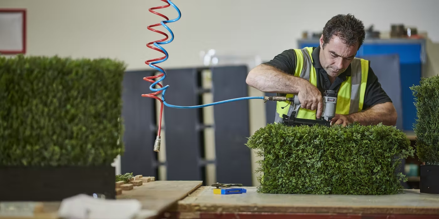 person-making-artificial-hedge-at-blooming-artificial